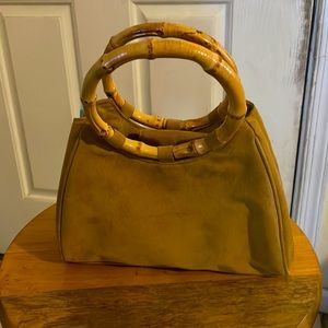 Small tan purse with wooden handles.
